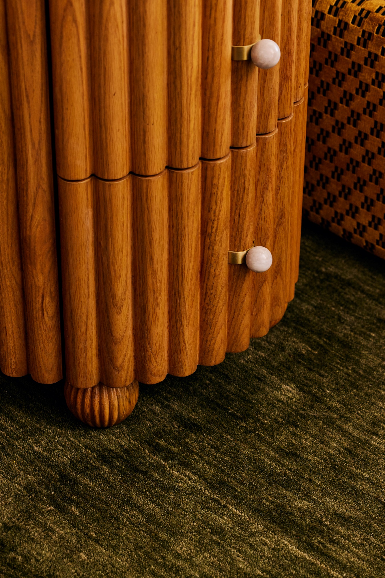 Detail shot of the a fluted nightstand with round marble knobs.